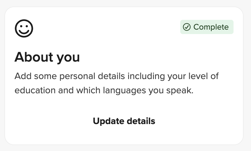 Eine Profilkarte aus dem UserTesting-Teilnehmerdashboard mit der Bezeichnung Infos über Sie. Die Karte zeigt ein Smiley-Gesichtssymbol und ein grünes Abzeichen mit der Aufschrift Vollständig. Sie fordert den Teilnehmer auf, persönliche Details wie ihren Bildungsstand und die von ihnen gesprochenen Sprachen hinzuzufügen. Unten wird eine fett gedruckte Schaltfläche Details aktualisieren zum Bearbeiten dieser Informationen angezeigt.